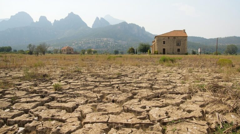 champ agricole catalan avec secheresse (avec detail de masia typique catalane de l'empordà bien identifiable qui permette de distinguer qu'on est en catalogne) et le montserrat derrière